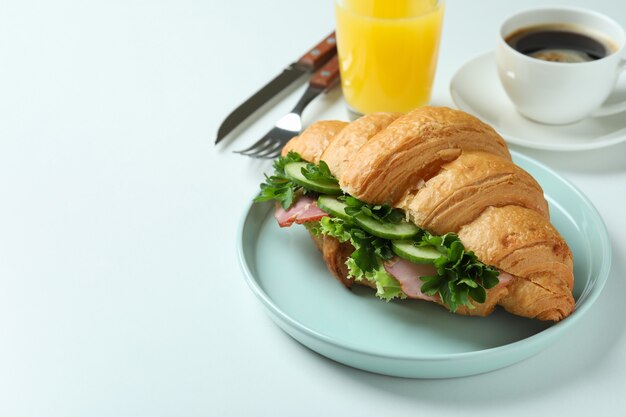 Concept van lekker eten met croissantsandwich op wit