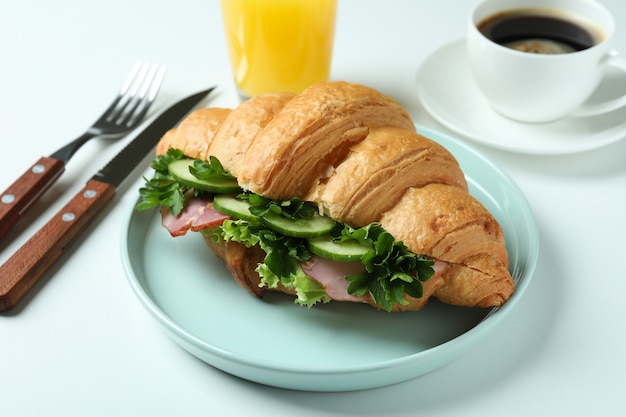 Concept van lekker eten met croissantsandwich op wit