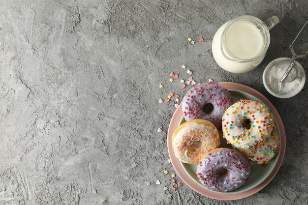 Concept van lekker eten met donuts en melk op grijze achtergrond