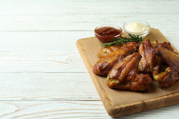 Concept van lekker eten met gebakken kippenvleugels op witte houten achtergrond