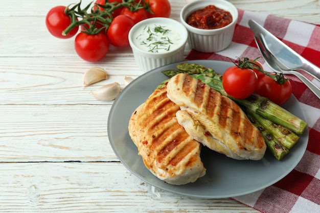 Concept van lekker eten met gegrilde kip op witte houten tafel