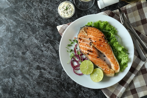 Concept van lekker eten met gegrilde zalm op zwarte rokerige tafel