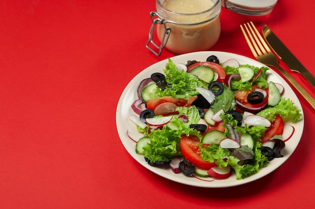 Concept van lekker eten met groentesalade met tahinisaus op rode achtergrond