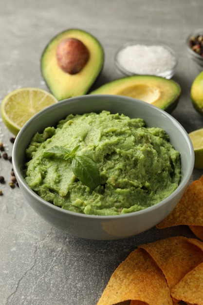 Concept van lekker eten met guacamole en ingrediënten op een grijze achtergrond