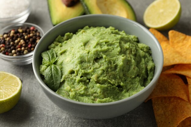 Concept van lekker eten met guacamole en ingrediënten op een grijze achtergrond