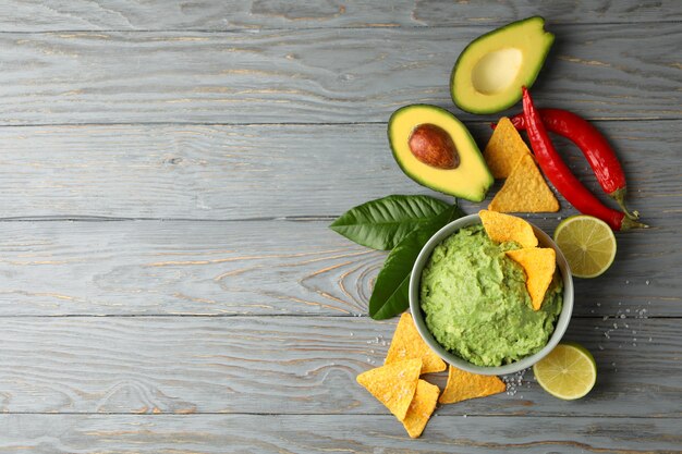 Concept van lekker eten met kom guacamole op houten achtergrond, ruimte voor tekst