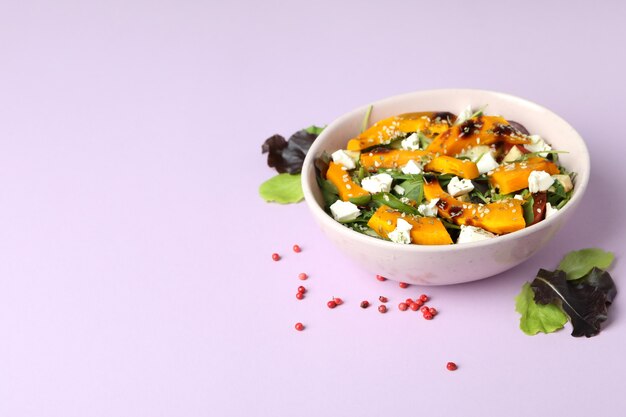 Concept van lekker eten met pompoensalade op violette achtergrond