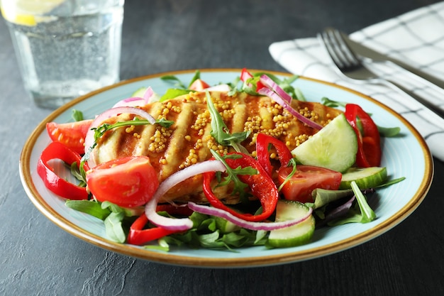 Concept van lekker eten met salade met gegrilde kip op donkere getextureerde tafel