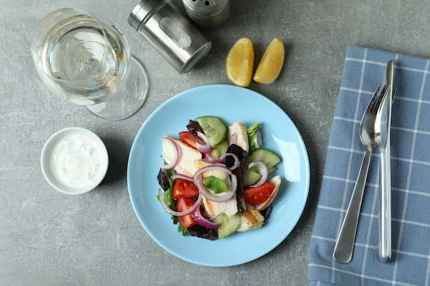 Concept van lekker eten met salade met gegrilde kip op grijze getextureerde tafel