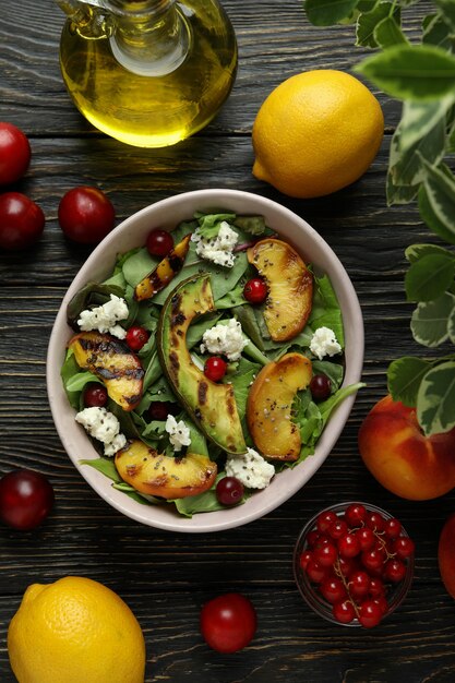 Concept van lekker eten met salade met gegrilde perzik op houten tafel