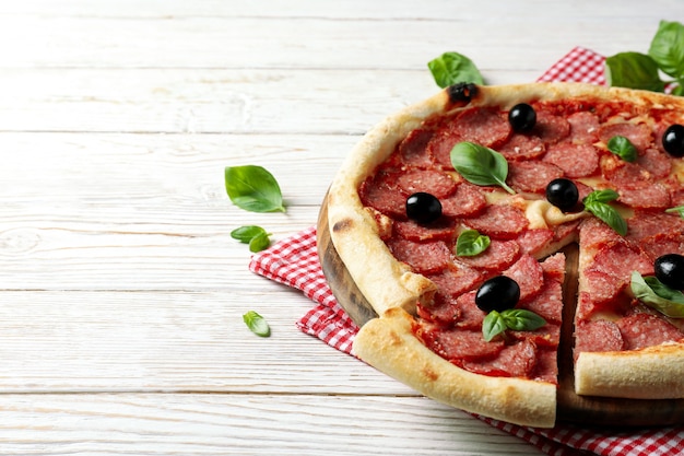 Concept van lekker eten met Salami pizza op witte houten achtergrond