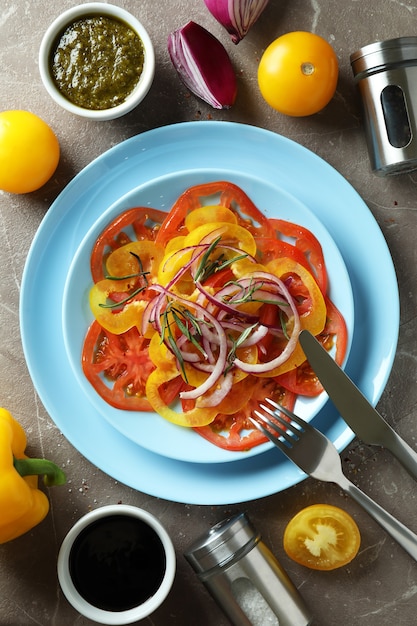 Concept van lekker eten met tomatencarpaccio op grijze getextureerde tafel