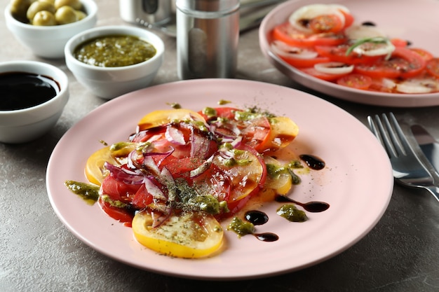 Concept van lekker eten met tomatencarpaccio op grijze getextureerde tafel