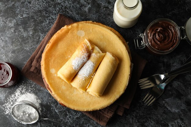 Concept van ontbijt met pannenkoeken met chocopasta op zwarte smokey tafel