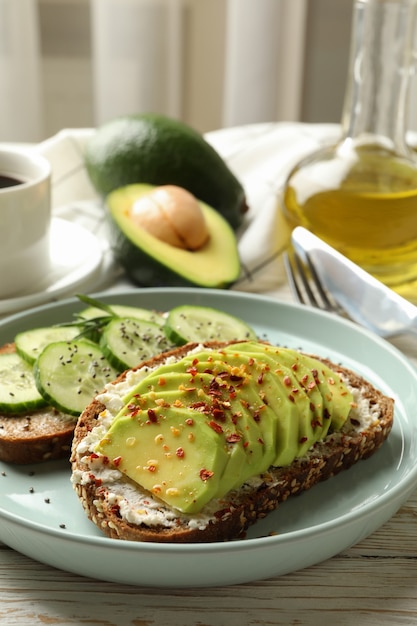 Concept van ontbijt met toast met avocado en komkommer op houten tafel