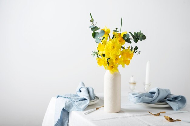 Concept van romantische paastafel met bloemen en wit tafelkleed selectieve focus afbeelding