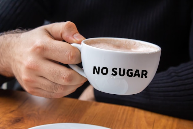 Foto concept van suikervrij. jonge man die koffie drinkt in een café. stop met het consumeren van suiker.