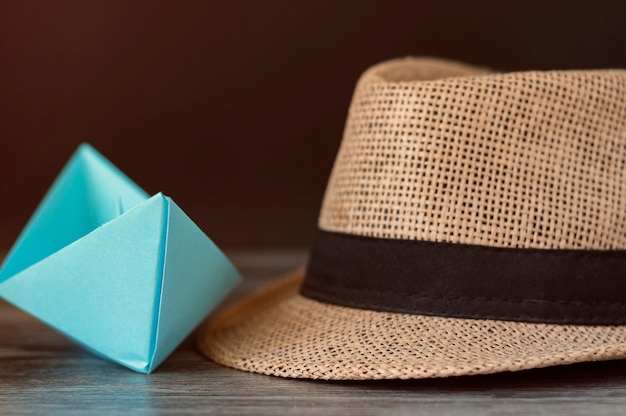 concept van toerisme, reizen. Blauw papier boot en zomer hoed op tafel.