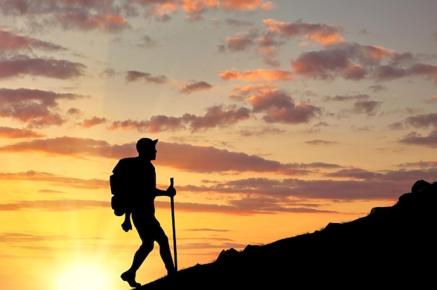 Concept van toerisme. Silhouetten van toeristen die de berg beklimmen bij zonsondergang