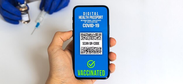 Concept van vaccinatie door een arts met COVID-19 coronavirusvaccin, veilig reisconcept met digitale gezondheidspaspoort-app, witte achtergrondfoto