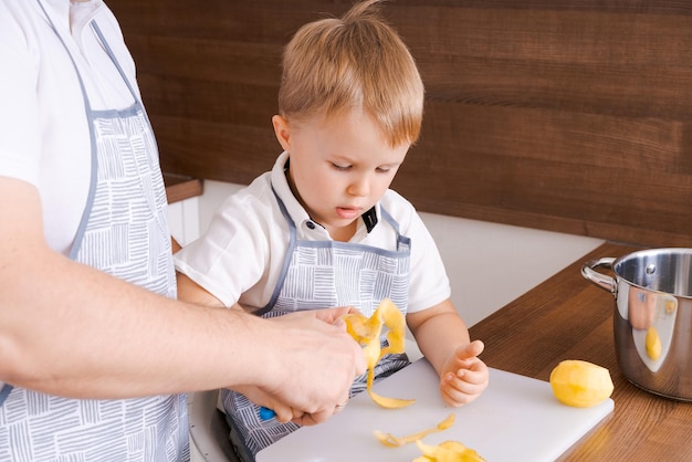 Concept voedsel en voeding shot van twee vrolijke vader en zoon poseren in de keuken