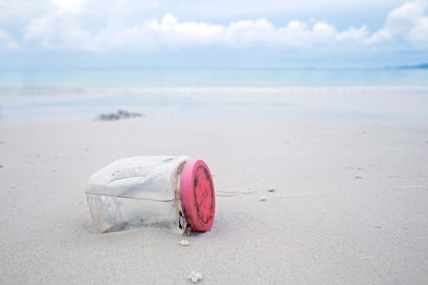 Concept voor milieu campagne. Plastic fles op het strand.