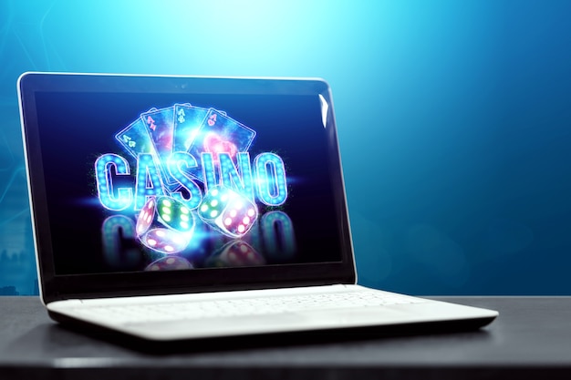 Concept voor online casino, gokken, online geldspellen, weddenschappen. neon casinofiches, casino-inscriptie, pokerkaarten, dobbelstenen vliegen uit de laptop.