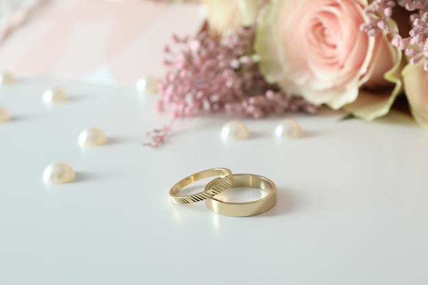 Concept of wedding accessories with wedding rings on white background