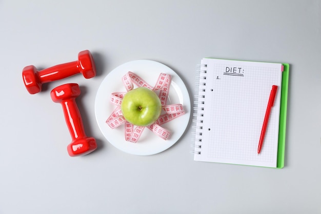 Photo concept of weight loss and healthy nutrition with apple and measuring tape