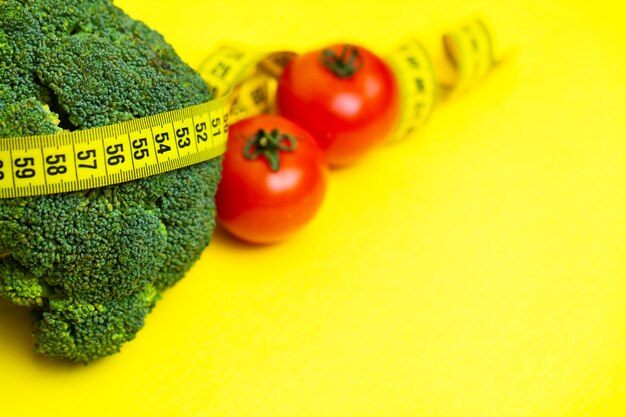 Concept of weight loss, vegetables with measuring tape