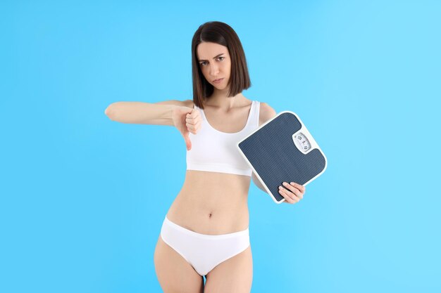 Concept of weight loss with thin girl on blue background