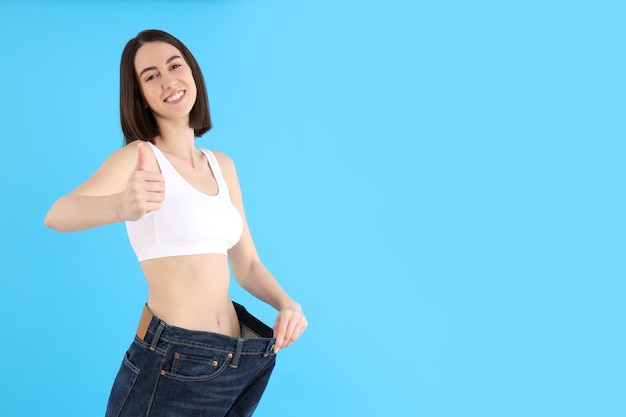 Concept of weight loss with thin girl on blue background