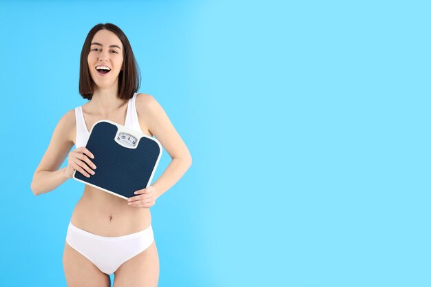 Concept of weight loss with young slim woman on blue background