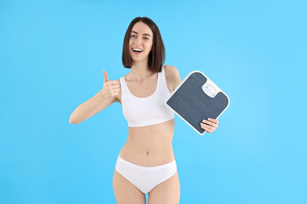 Concept of weight loss young woman on blue background