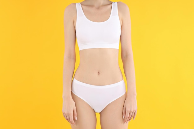 Concept of weight loss young woman on yellow background