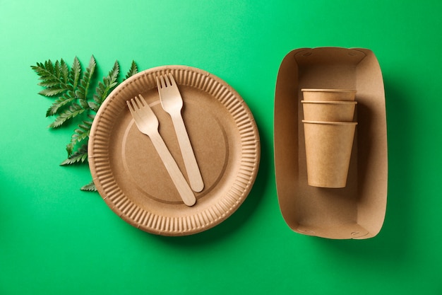 Concept with eco - friendly tableware and plant on green, copy space