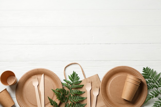 Concept with eco - friendly tableware and plant on wooden, copy space