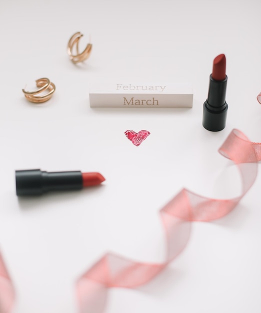 Concept womens day valentines day march  lipsticks cosmetic makeup products and accessories flatlay ...