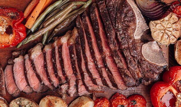 Foto concetto di una cena meravigliosa per due di un delizioso succoso agricoltore fresco bistecca di manzo marmorizzata alla griglia con verdure al forno