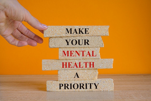 Concept words make your mental health a priority on brick blocks on a beautiful orange background