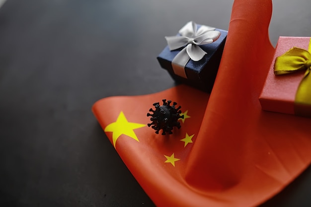 The concept of the world coronavirus pandemic. The geographical location of the virus. China flag and virus model and gift box.