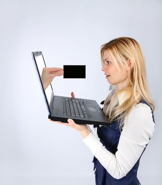 Conceptdiensten en reclame. Verrast vrouw met een laptop en hand met visitekaartje