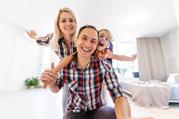 Conceptfamilie: Gelukkig jong gezin in het nieuwe droom- en planinterieur van het appartement