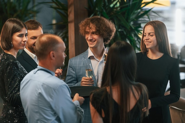 Conception of celebrating event Group of people in elegant clothes are in the restaurant