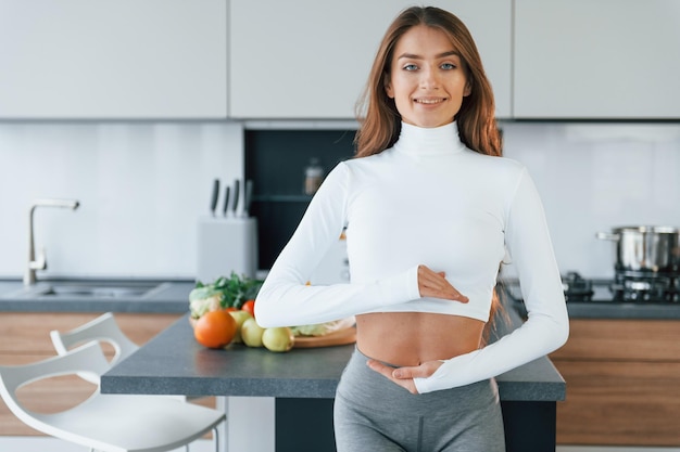 Conception of dieting Young european woman is indoors at kitchen indoors with healthy food