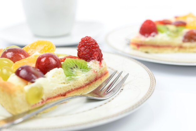 Conception of healthy fruit dessert fresh homemade multi fruit tart on plates with cup of coffee in closeup