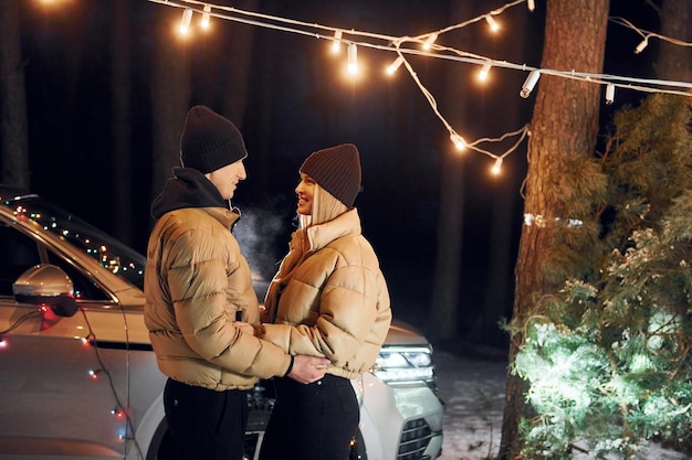 Concezione dell'amore coppia in piedi nella foresta e festeggiare il nuovo anno