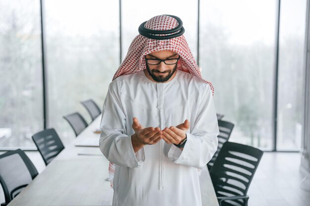 Conception of rich person Successful Muslim businessman in traditional outfit in his office