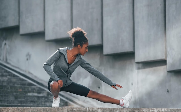 スポーツの概念スポーツ服を着た若いアフリカ系アメリカ人女性は、日中に屋外でトレーニングをしています