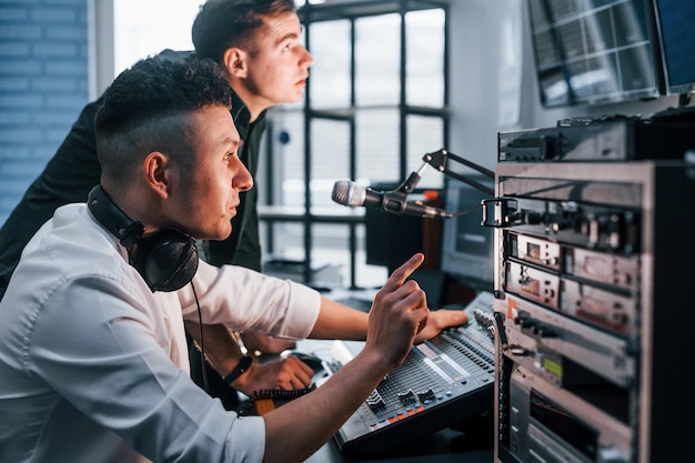 팀워크의 개념 라디오 스튜디오에서 실내에 있는 두 남자는 방송으로 바쁘다